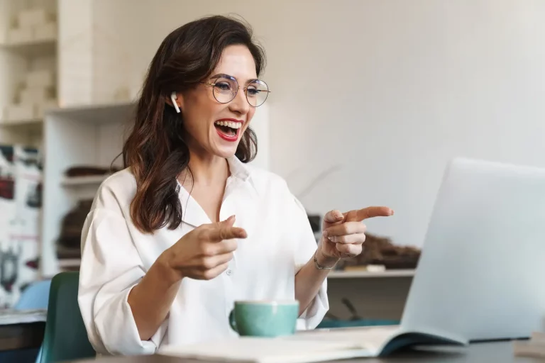 Lächelnde Frau am Laptop beim Beratungsgespräch.